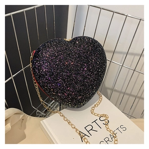Close-up of heart-shaped crossbody bag with black multi-color sequins and gold chain