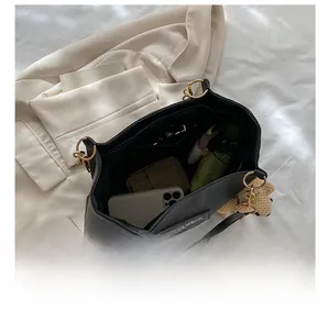 Top view of spacious black PU tote interior holding phone, wallet, and umbrella