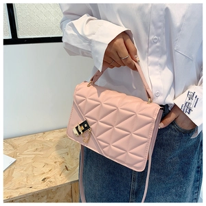 Detailed view of pink quilted handbag with premium black and gold square lock and chain