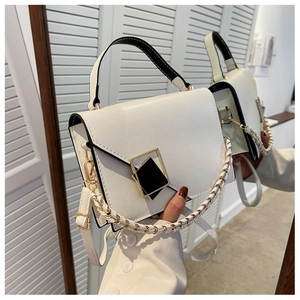 Detail of white leather crossbody bag with golden metal lock and dual detachable straps