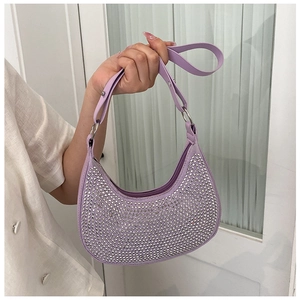 Detail view of purple underarm bag featuring shimmering silver rhinestones and leather strap