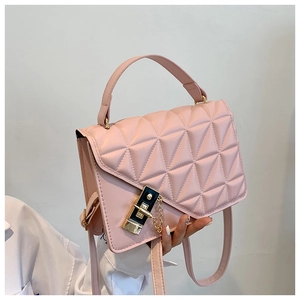 Close-up of pink quilted handbag showing detailed stitching and golden metal lock buckle
