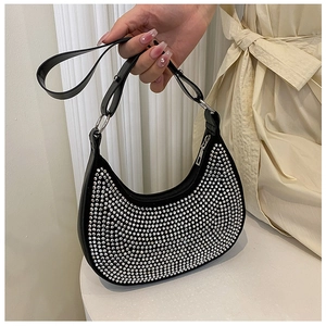 Detail of black crescent shoulder bag with sparkling rhinestone texture and metal buckles