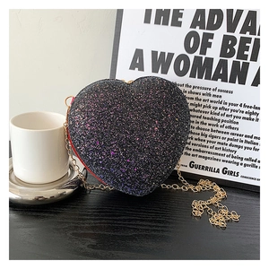 Detail of heart-shaped glitter bag with black sequins and gold chain strap