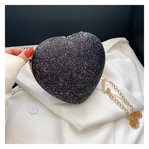 Detail of heart-shaped glitter evening bag with gold chain strap and shimmering sequins