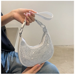 Close-up of sparkling silver rhinestones and white PU leather on the chic hobo bag