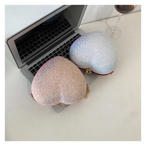 Macro shot of glittery heart-shaped crossbody bags in silver-blue and pink gold sparkles