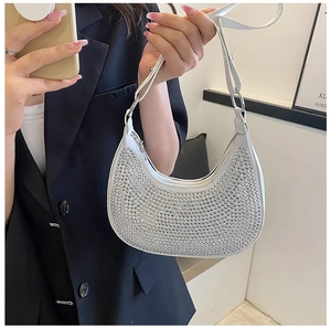 Detail of white crescent bag with silver rhinestones and a metallic zipper closure