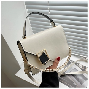 Detail of cream leather handbag with asymmetric V-flap and elegant black gold geometric lock