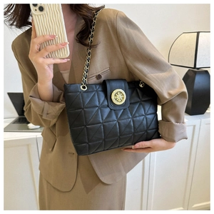 Détail du sac bandoulière noir matelassé avec boucle ronde en métal doré de style rétro