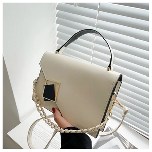 Detail of cream flap crossbody bag with gold square buckle and chain woven strap