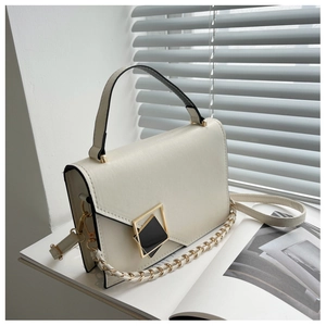 Detail of white leather handbag with gold geometric buckle and braided metal chain strap