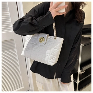 Détail du sac cabas matelassé blanc avec boucle dorée et bandoulière en chaîne