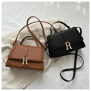 Detail of high-quality leather square bags with golden R-letter buckles and long straps