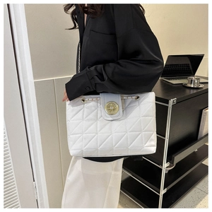 Détail du sac matelassé blanc avec fermoir en métal doré et bandoulière en chaîne