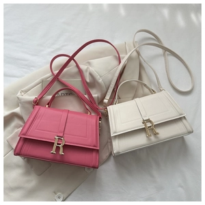 Detail of pink and beige crossbody bags with metallic R buckle and vertical stitching