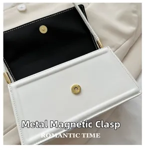 Close-up van witte leren tas met hoogwaardige gouden magnetische metalen hardware gesp