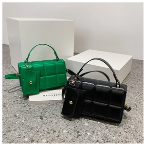 Dettaglio di borse trapuntate verdi e nere con mini portamonete e accessori in metallo oro