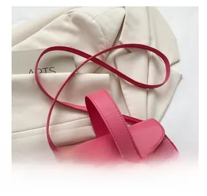 Détail du sac à main rose gaufré crocodile avec fermoir doré et bandoulière réglable