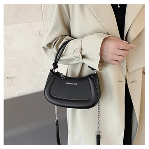 Detail of black leather crescent bag with silver chain strap and fashion logo