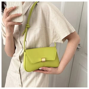 Close-up of fluorescent green leather crossbody bag with elegant gold buckle hardware