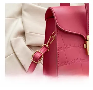 Gros plan du sac à main rose vif avec motif crocodile et fermoir métallique doré