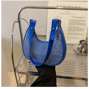 Detailed shot of a blue crescent underarm bag with shimmering silver rhinestones
