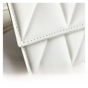 Close-up of white quilted leather texture and fine stitching on a square chain bag
