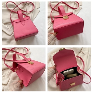 Vue détaillée du sac à main rose à motif croco montrant l'intérieur et le fermoir doré