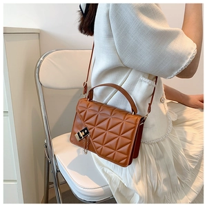 Side view of a brown quilted crossbody bag with metal chain detail and leather texture