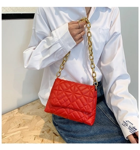 Detail of red quilted PU leather shoulder bag with chunky gold chain strap