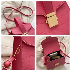 Détail du sac rose embossé croco avec fermoir doré et espace intérieur pour téléphone