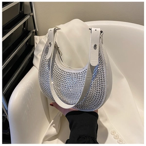 Close-up of white crescent bag featuring shimmering rhinestones and silver hardware