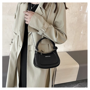 Detail of a black half-moon crossbody bag featuring silver chain strap and metal zipper