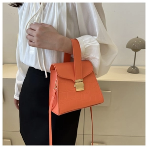 Détails du sac à main orange à texture crocodile avec une boucle en métal doré
