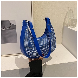 Close-up of royal blue hobo bag featuring sparkling silver rhinestones and metal rings
