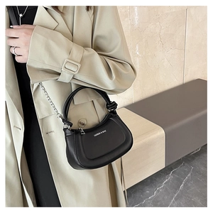 Detail of a black crescent hobo bag featuring silver chain strap and knotted top handle