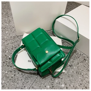 Dettaglio della borsa a tracolla verde con motivi trapuntati a quadri e fibbia dorata