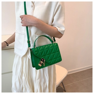 Detail showing bright green quilted handbag with gold clasp and matching chain strap