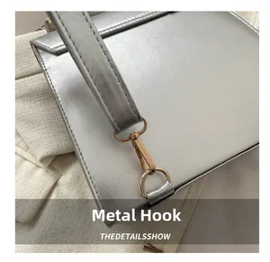 Detail of high-quality polished gold metal hooks on a silver vintage backpack