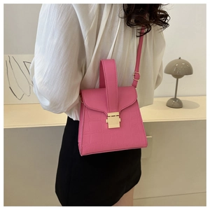 Vue détaillée du sac à main rose à motif crocodile avec fermoir en métal doré et poignée