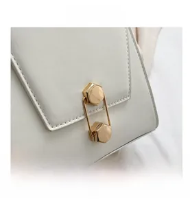 Macro detail of high-quality white leather handbag with elegant gold hexagonal metal lock
