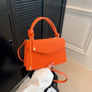 Orange woven leather shoulder bag with top handle and elegant knotted detail