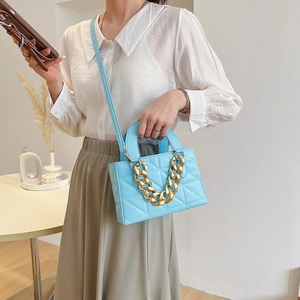 Blue quilted handbag with thick gold chain strap and detachable crossbody shoulder strap