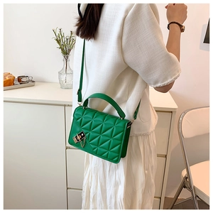 Close-up of green quilted crossbody bag showing side view and golden hardware detail