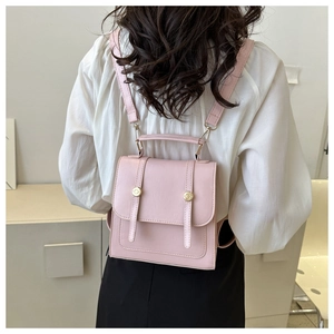 Detail of pink PU leather backpack with gold buckle and flap closure on model