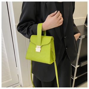 Détail du sac à main vert fluo texture crocodile avec fermoir métallique doré rectangulaire