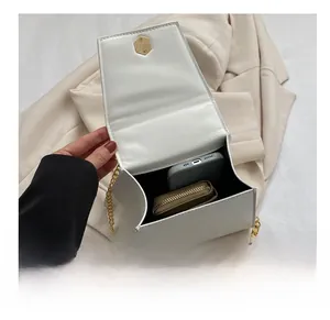 Interior view of white trapezoid bag showing capacity for phone and gold chain detail