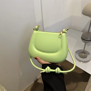 Neon green mini PU leather shoulder bag with rounded design and knotted strap details