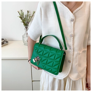 Detail of green PU leather crossbody bag featuring geometric triangle quilting and gold clasp